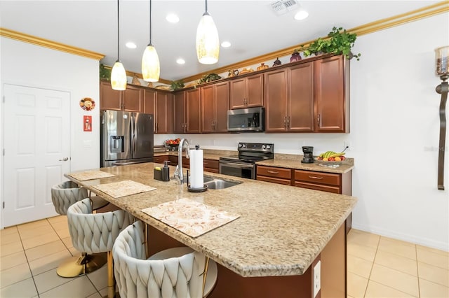 kitchen with sink, a breakfast bar area, crown molding, appliances with stainless steel finishes, and an island with sink