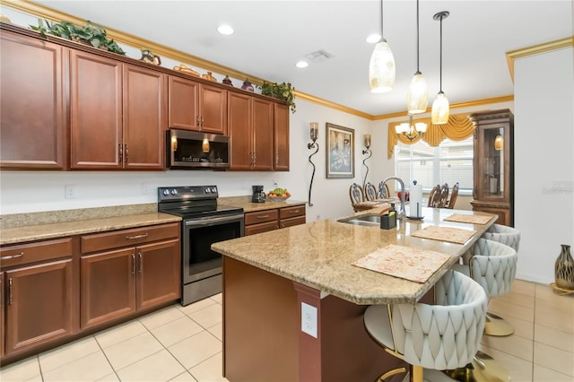 kitchen with a breakfast bar, sink, a center island with sink, ornamental molding, and stainless steel appliances