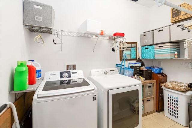 washroom with washing machine and clothes dryer and light tile patterned floors