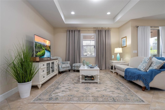 living area featuring light tile patterned floors and a tray ceiling