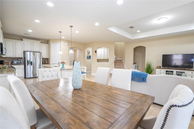 tiled dining room with a tray ceiling