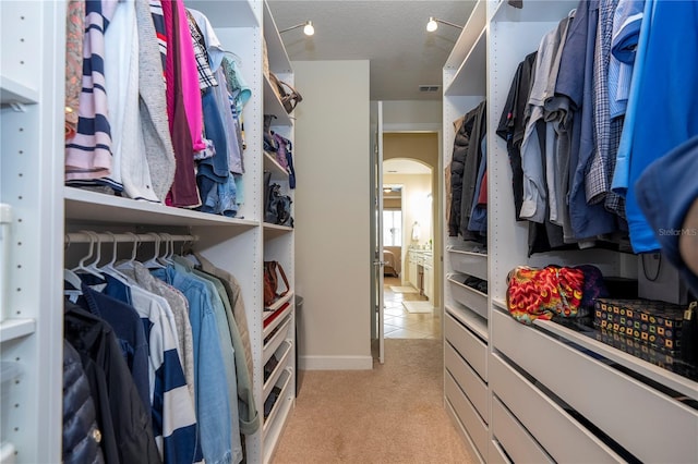 walk in closet featuring light carpet