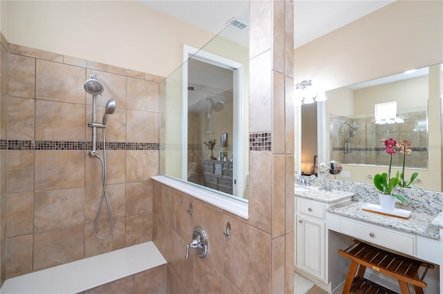 bathroom featuring vanity and tiled shower