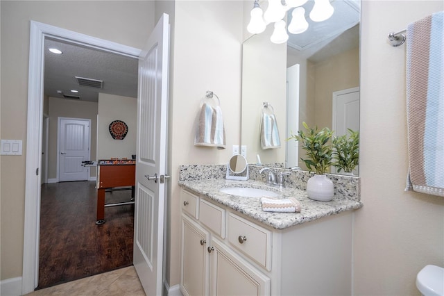 bathroom featuring vanity, tile patterned floors, and a textured ceiling