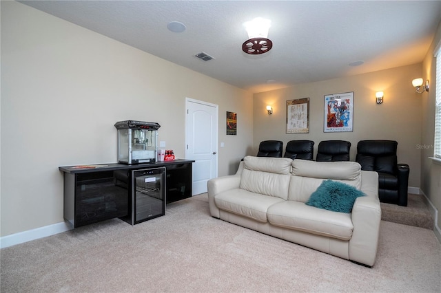 carpeted cinema room featuring indoor bar and wine cooler