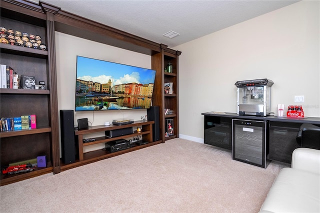 home theater room with light colored carpet, beverage cooler, and a textured ceiling