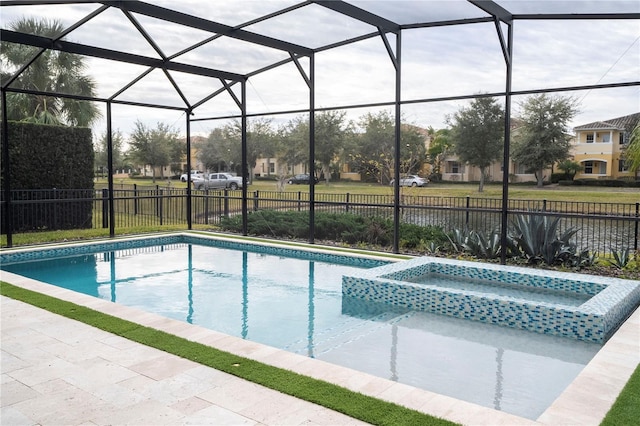 view of pool with a patio area, an in ground hot tub, and glass enclosure