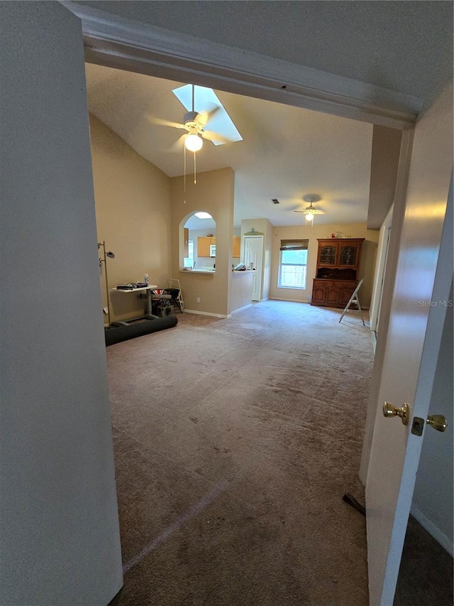 unfurnished living room with vaulted ceiling, carpet floors, and ceiling fan