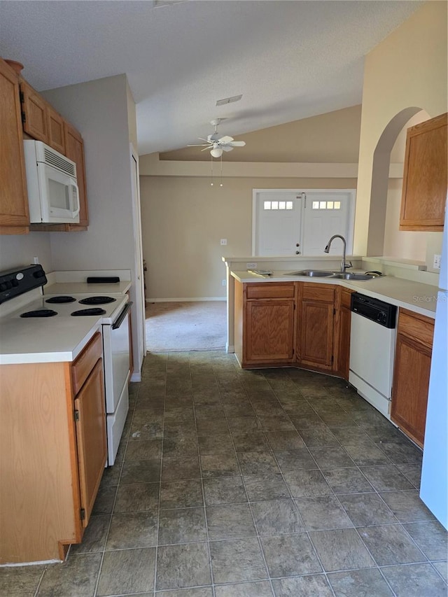 kitchen with lofted ceiling, sink, white appliances, and kitchen peninsula