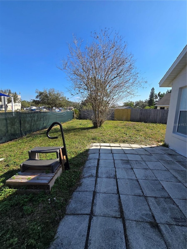 view of pool with a patio and a lawn