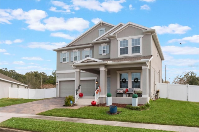 craftsman inspired home with a garage, a front lawn, and a porch