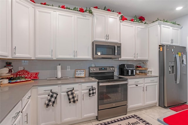 kitchen with white cabinetry, light tile patterned floors, tasteful backsplash, and stainless steel appliances