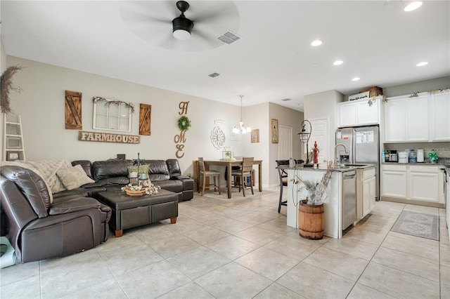 living room featuring sink, ceiling fan, and light tile patterned flooring