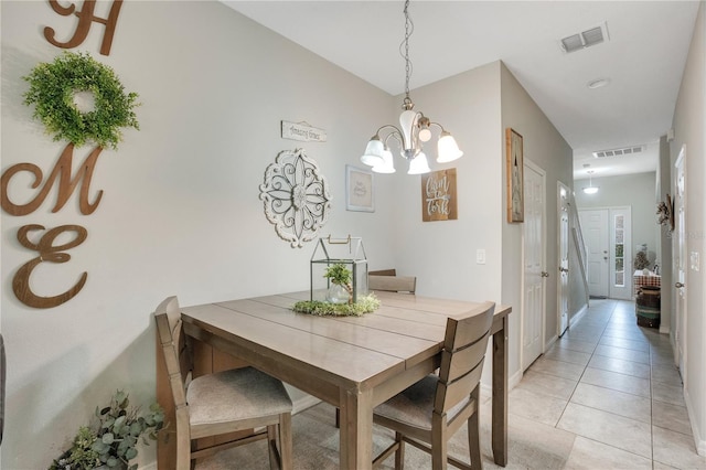 tiled dining space with a chandelier