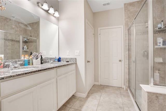 bathroom featuring tile patterned floors, an enclosed shower, and vanity