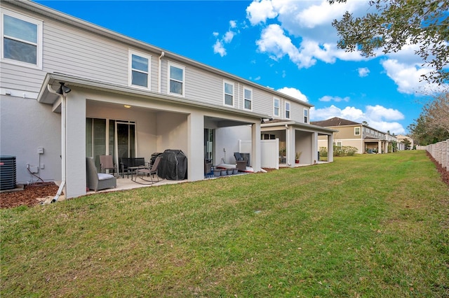 rear view of house with a yard and a patio