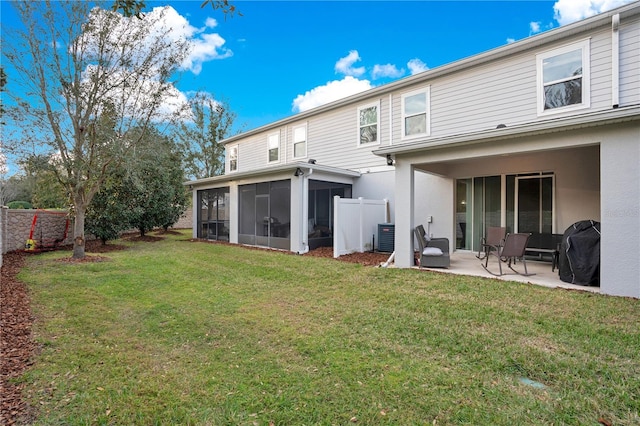 rear view of house featuring a lawn, a sunroom, central air condition unit, and a patio area