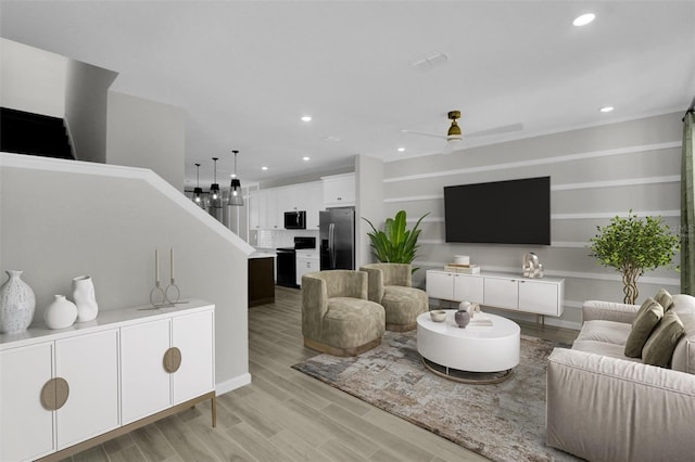 living room with ceiling fan and light hardwood / wood-style floors