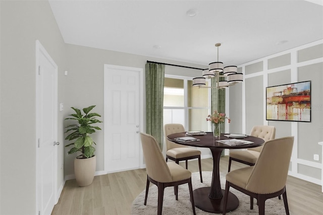 dining room with a notable chandelier and light hardwood / wood-style flooring