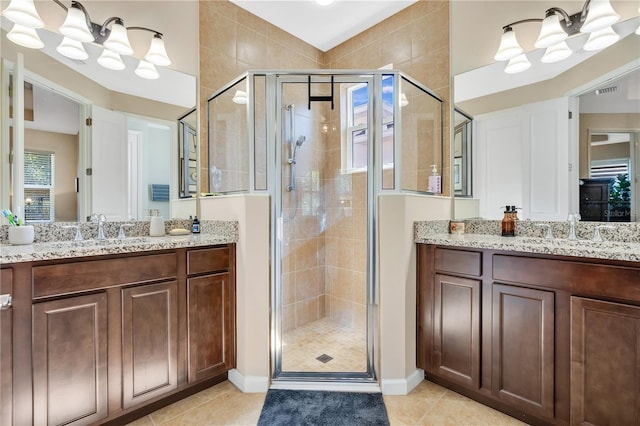 bathroom with tile patterned flooring, vanity, a chandelier, and a shower with shower door