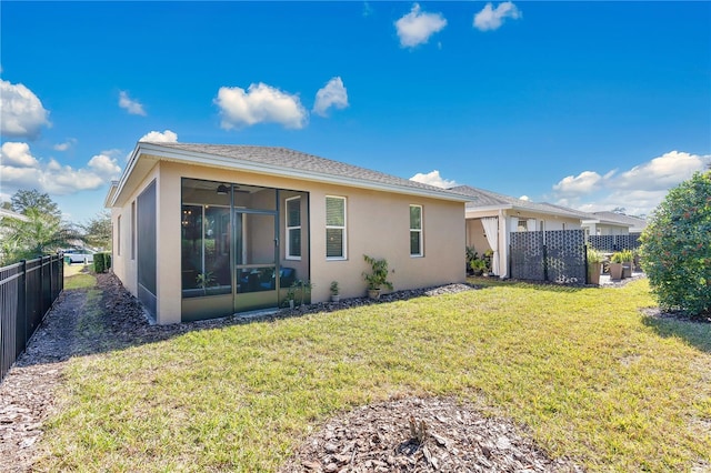 rear view of property with a yard and a sunroom