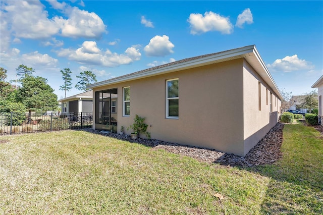 rear view of property featuring a sunroom and a yard