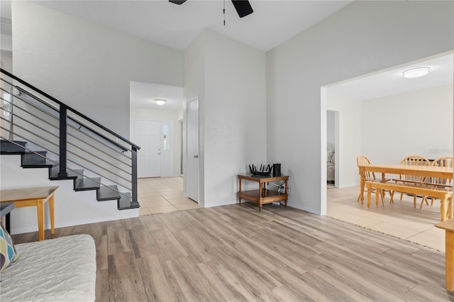 entryway featuring a high ceiling, ceiling fan, and light wood-type flooring