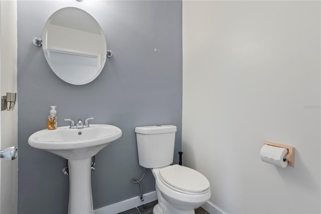 bathroom with sink, toilet, and tile patterned flooring