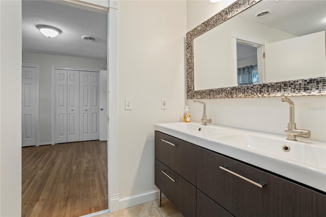 bathroom with vanity, hardwood / wood-style floors, and a textured ceiling