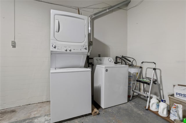 clothes washing area featuring stacked washer and clothes dryer