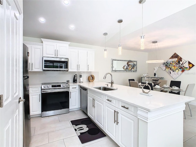 kitchen featuring sink, appliances with stainless steel finishes, hanging light fixtures, white cabinets, and kitchen peninsula