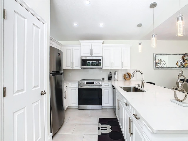 kitchen with appliances with stainless steel finishes, pendant lighting, white cabinetry, sink, and kitchen peninsula