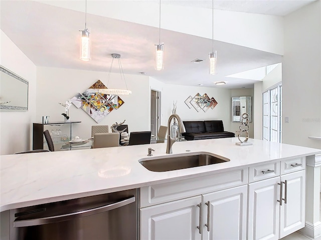 kitchen with sink, stainless steel dishwasher, hanging light fixtures, and white cabinets