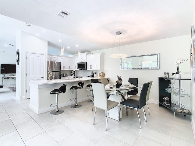 tiled dining room with vaulted ceiling and sink