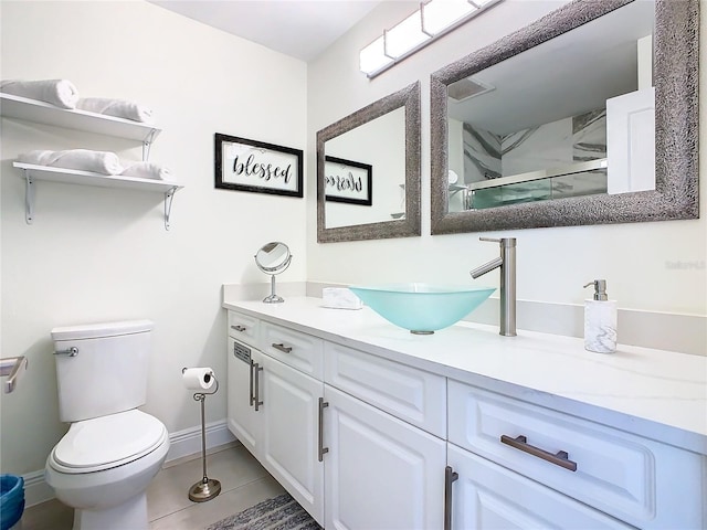 bathroom with a shower with door, vanity, tile patterned flooring, and toilet