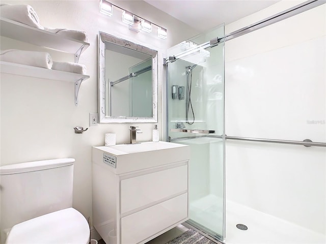 bathroom with vanity, toilet, and a shower with door