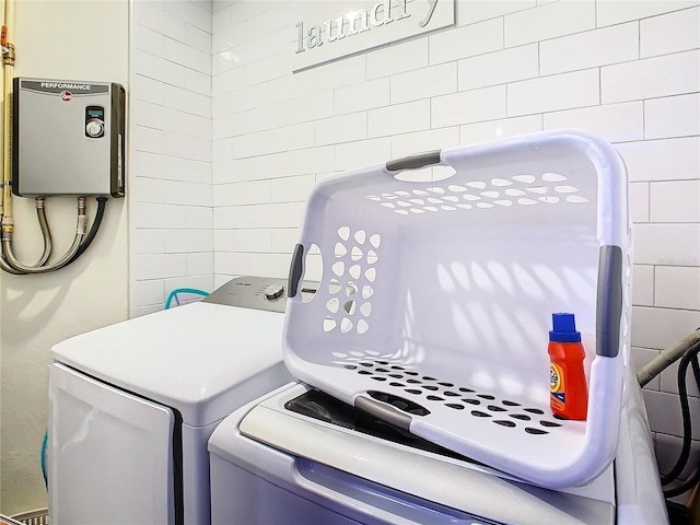 laundry room with water heater and washing machine and clothes dryer