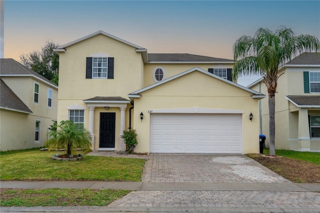 view of front of property featuring a garage and a lawn