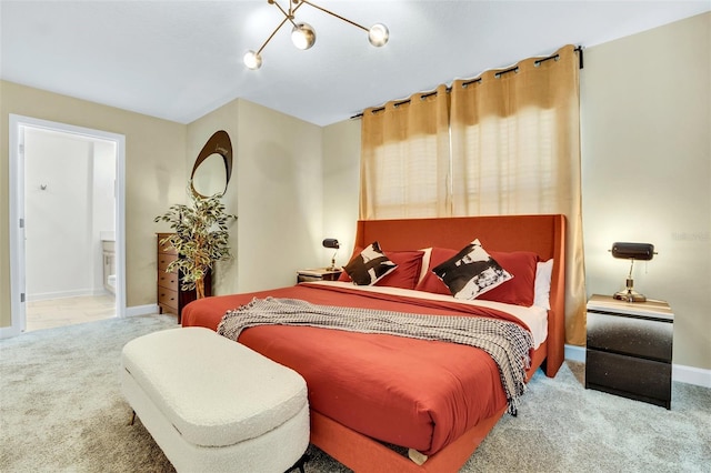 bedroom with ensuite bathroom and carpet flooring