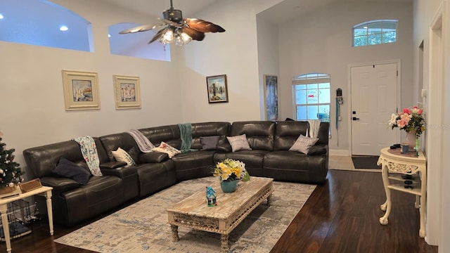 living room with ceiling fan, dark hardwood / wood-style flooring, and high vaulted ceiling