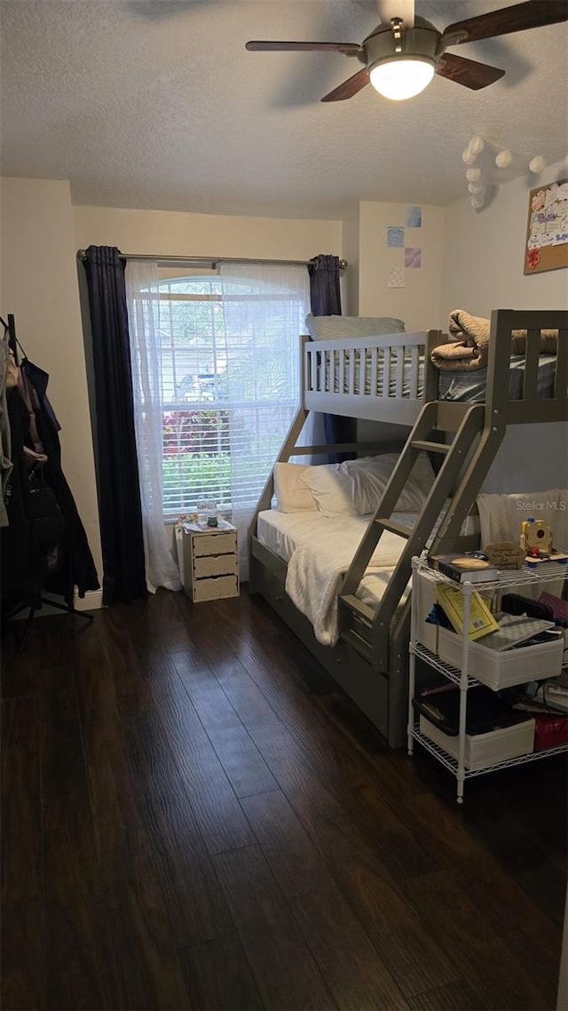 bedroom with dark hardwood / wood-style floors, a textured ceiling, and ceiling fan