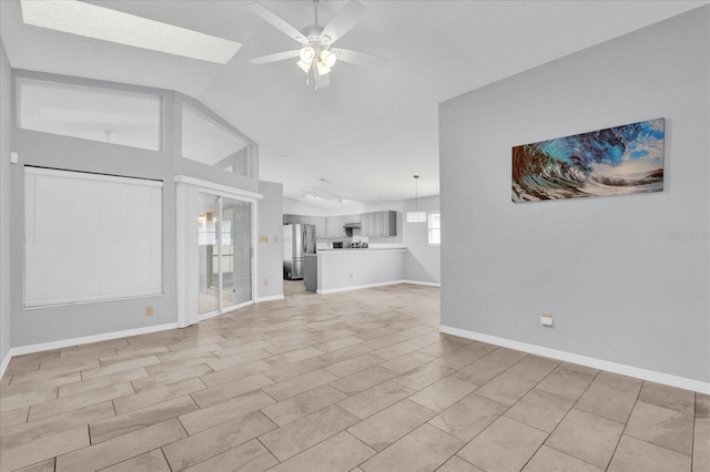 unfurnished living room with ceiling fan and vaulted ceiling