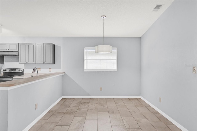 kitchen with visible vents, gray cabinets, under cabinet range hood, stainless steel range with electric cooktop, and baseboards