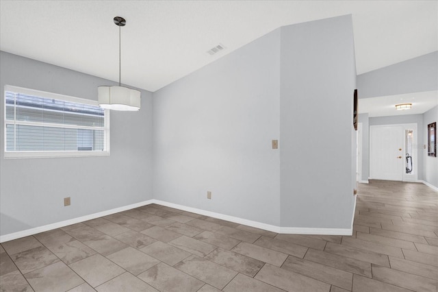 unfurnished room featuring visible vents, baseboards, and vaulted ceiling