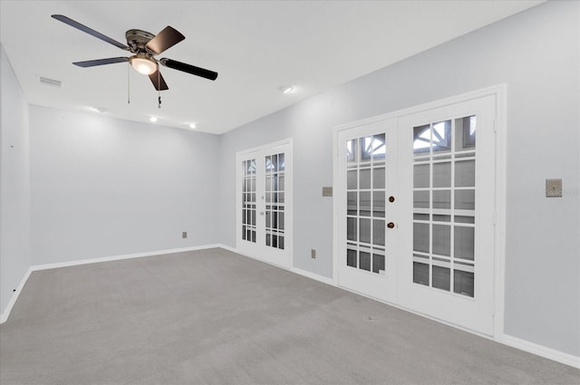 carpeted empty room with ceiling fan, french doors, visible vents, and baseboards