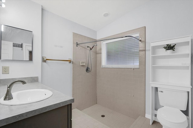 full bathroom featuring vanity, toilet, vaulted ceiling, and a tile shower