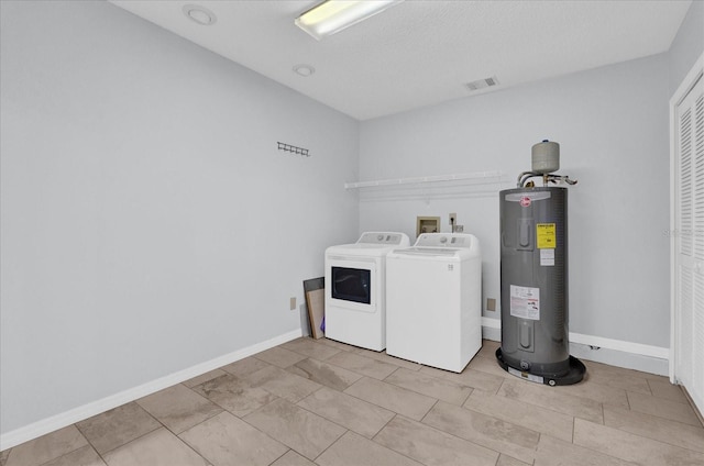 laundry area featuring washing machine and clothes dryer, visible vents, electric water heater, baseboards, and laundry area