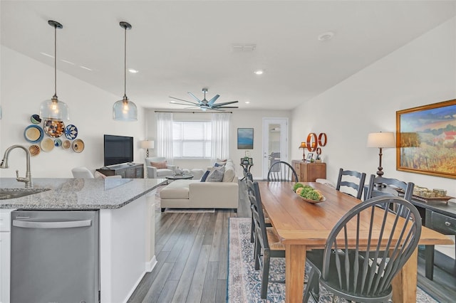 dining room featuring ceiling fan, sink, and dark hardwood / wood-style flooring