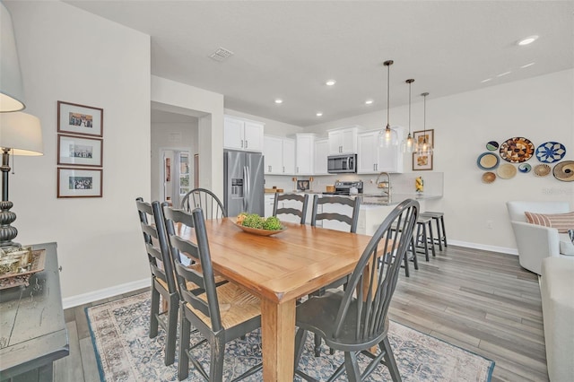 dining area with sink and light wood-type flooring