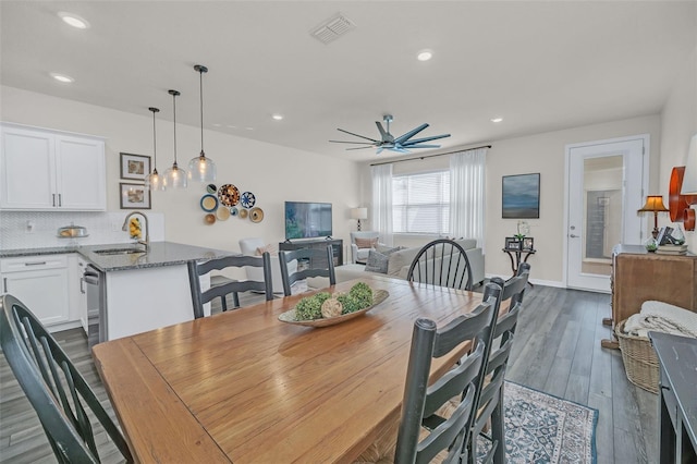 dining room featuring ceiling fan, sink, and dark hardwood / wood-style floors